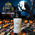 Ivory pillar candle with a raised flying dragon, spread wings, and curled tail against a moonlit Halloween backdrop.