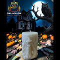 An off-white carved pillar candle featuring a witch and pumpkin design, set against a spooky Halloween night backdrop with a haunted house, full moon, owl on a tree branch, and pumpkins. The 'Owl Hollow Candle Company' logo is visible in the top left corner.
