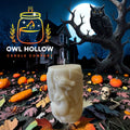 Ivory pillar candle with a raised winged dragon and curled tail, displayed against a moonlit Halloween backdrop.